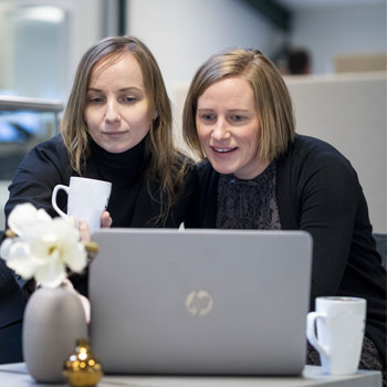 Two people looking at a laptop