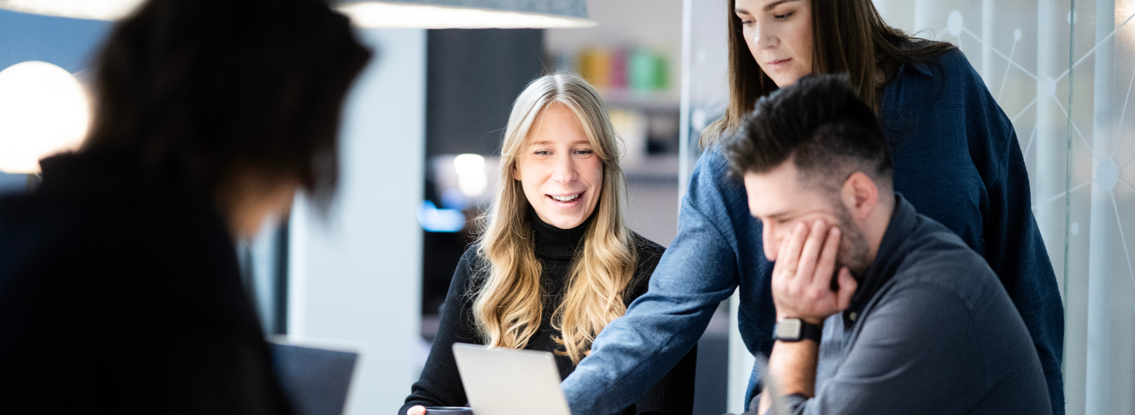 Photo of two women and one man collaborating in the office.
