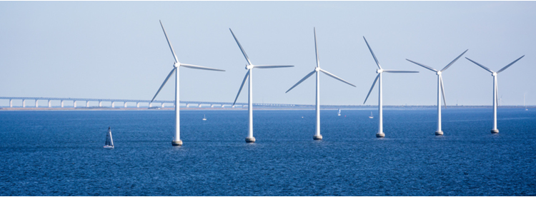 Photo of the Oresunds bridge between Denmark and Sweden. Wind power plant in front of the bridge.