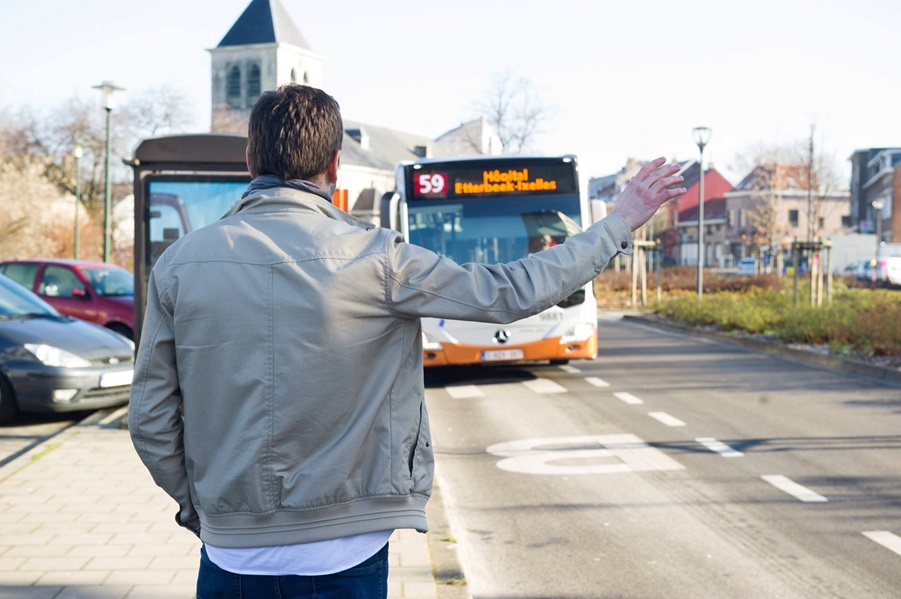 Passenger waving at STIB bus to pick him up.